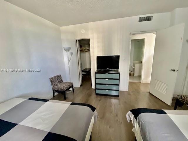 bedroom featuring a spacious closet, a closet, and hardwood / wood-style floors