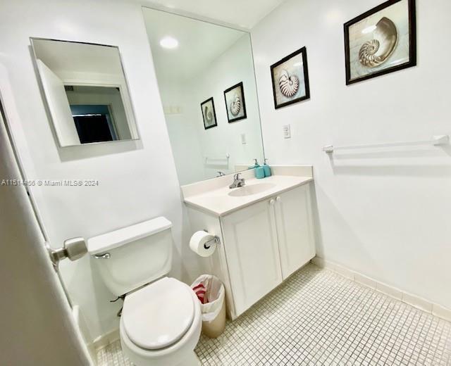 bathroom with tile patterned flooring, vanity, and toilet