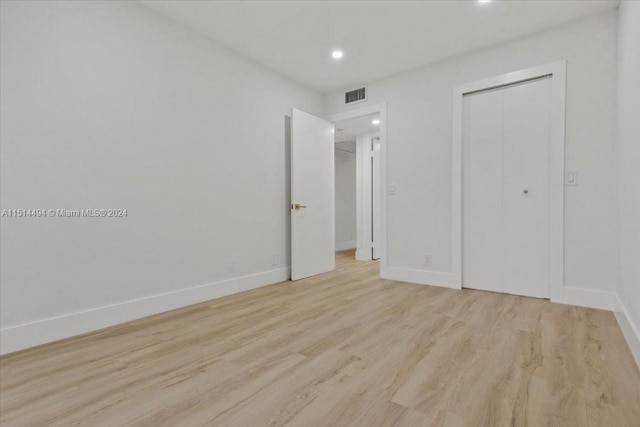 unfurnished bedroom featuring a closet and light wood-type flooring