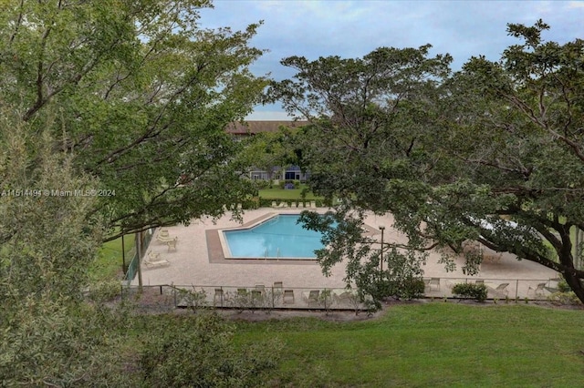 view of swimming pool featuring a lawn