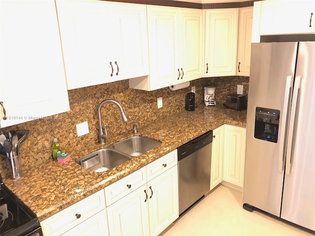 kitchen featuring dark stone countertops, decorative backsplash, sink, stainless steel appliances, and white cabinets