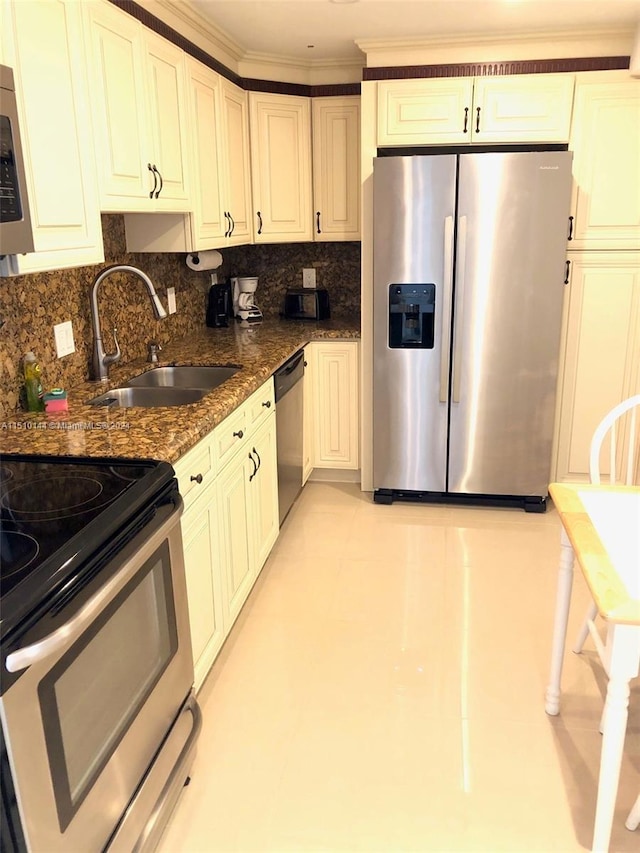 kitchen with decorative backsplash, sink, appliances with stainless steel finishes, and dark stone counters