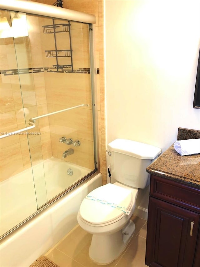 full bathroom with enclosed tub / shower combo, tile patterned floors, vanity, and toilet