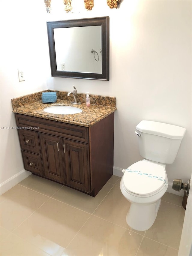 bathroom with toilet, tile patterned flooring, and vanity