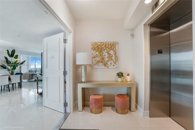 hallway featuring light tile flooring and elevator