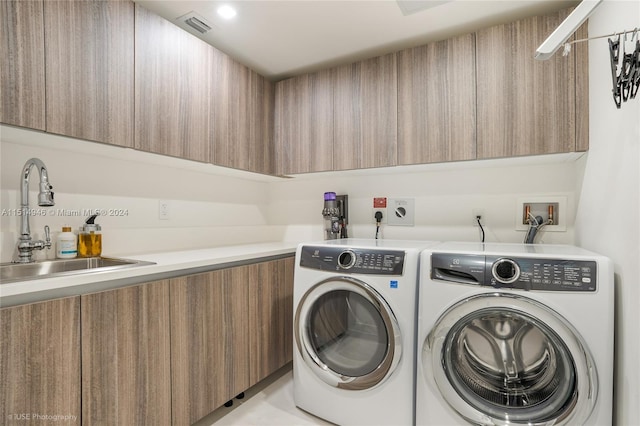 laundry area with washer hookup, hookup for an electric dryer, cabinets, independent washer and dryer, and sink