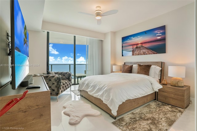 bedroom featuring light tile floors, access to exterior, ceiling fan, floor to ceiling windows, and a water view