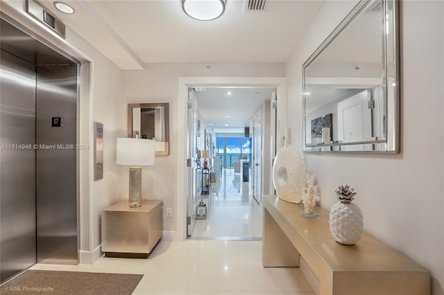 corridor with light tile flooring and elevator