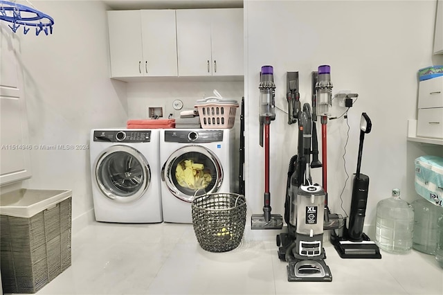 laundry area featuring hookup for a washing machine, washing machine and clothes dryer, and cabinets