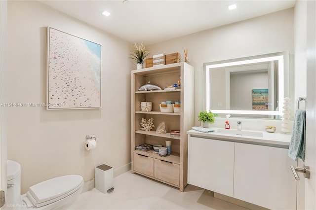 bathroom with toilet, tile floors, and vanity