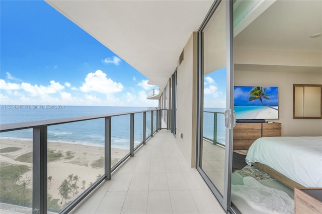 balcony with a water view and a view of the beach