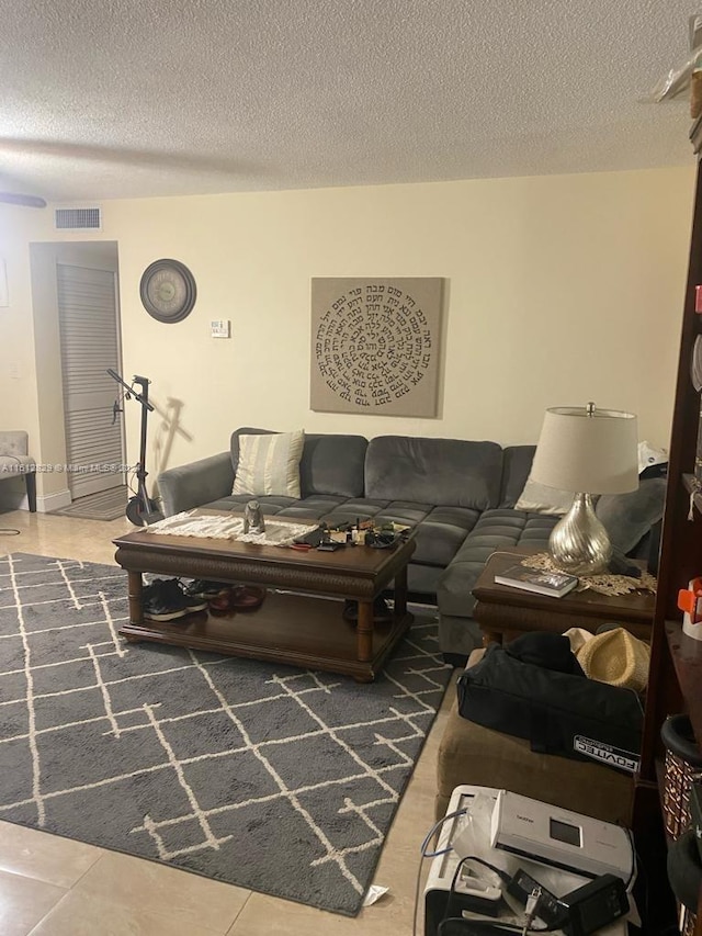 tiled living room featuring a textured ceiling