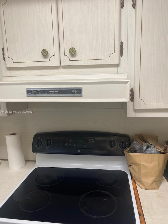 details featuring black range oven and light brown cabinets