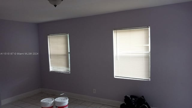 spare room with light tile flooring and plenty of natural light