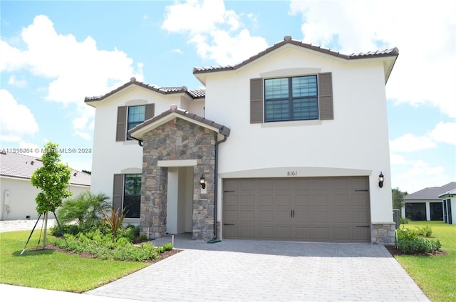 mediterranean / spanish-style home with a front lawn and a garage