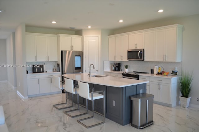 kitchen featuring a kitchen island with sink, white cabinets, sink, and stainless steel appliances