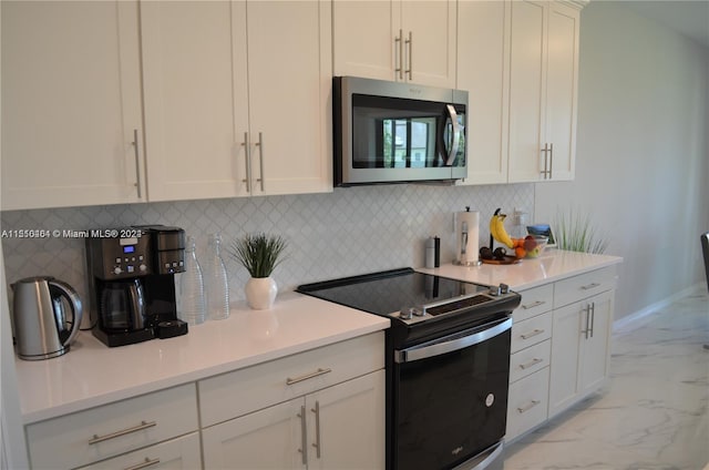 kitchen featuring white cabinets, light tile floors, tasteful backsplash, and range with electric stovetop