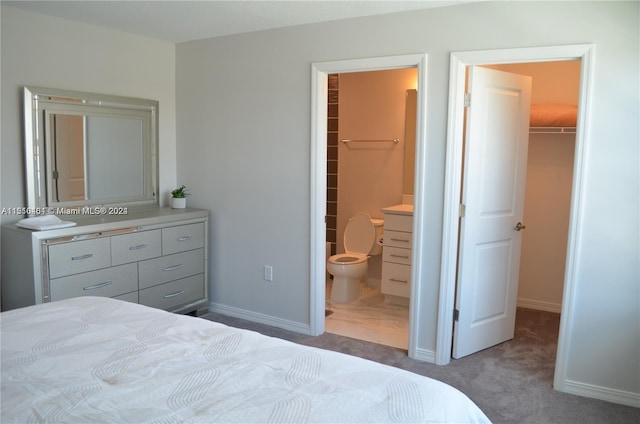 carpeted bedroom with a closet, a walk in closet, and ensuite bathroom