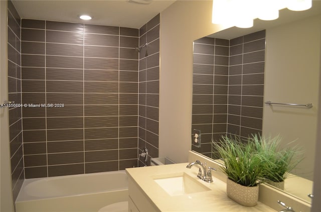 full bathroom featuring tiled shower / bath, toilet, and oversized vanity