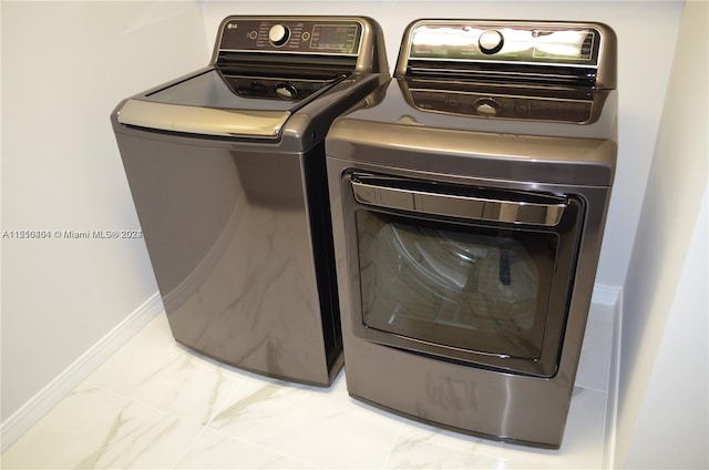 washroom with light tile floors and washing machine and clothes dryer