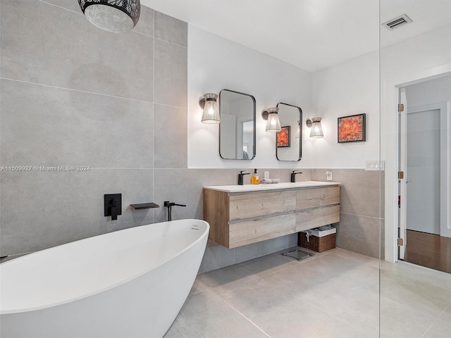 bathroom with tile walls, tile patterned flooring, and vanity