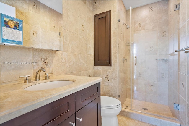 bathroom featuring tile walls, a shower with shower door, tile patterned flooring, vanity, and toilet