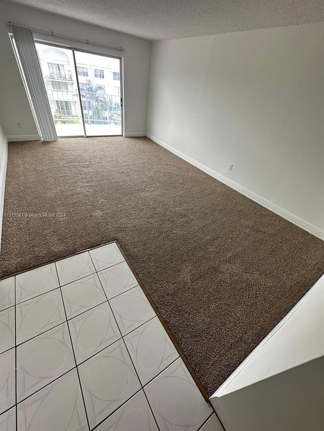 unfurnished room with light carpet and a textured ceiling