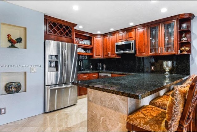 kitchen with a breakfast bar area, tasteful backsplash, appliances with stainless steel finishes, and light tile floors