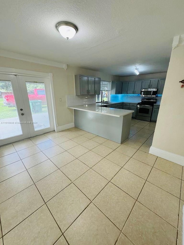 kitchen featuring light tile floors, french doors, and stainless steel appliances