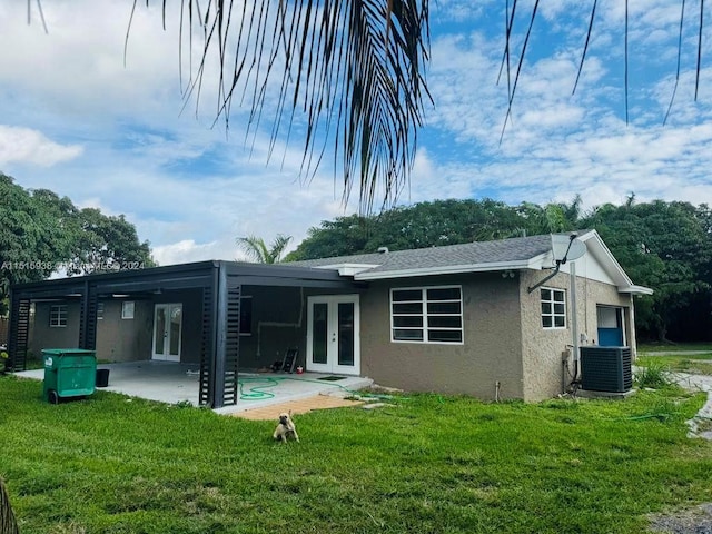 back of house with french doors, central AC, a lawn, and a patio area