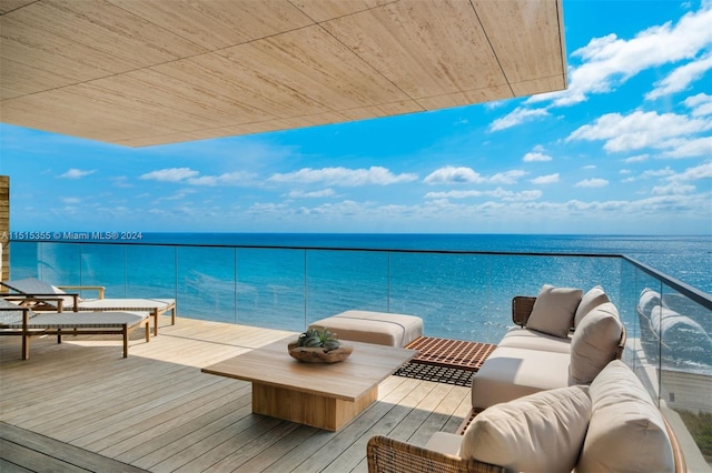 balcony with an outdoor living space and a water view