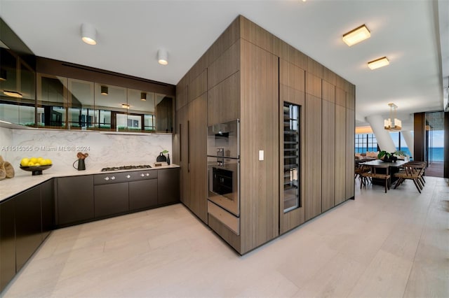 kitchen featuring decorative backsplash, pendant lighting, an inviting chandelier, and stainless steel gas stovetop