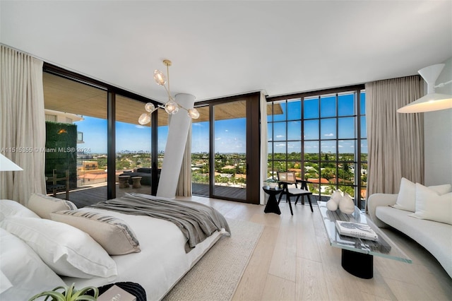 bedroom featuring hardwood / wood-style floors, floor to ceiling windows, and access to exterior