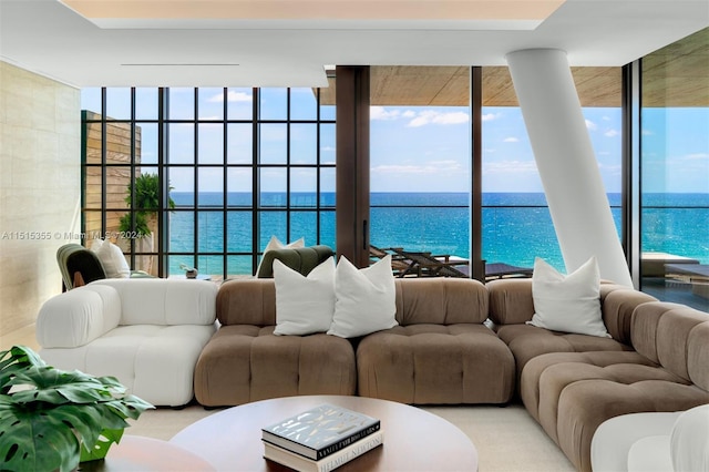 living room with a water view, plenty of natural light, and a wall of windows