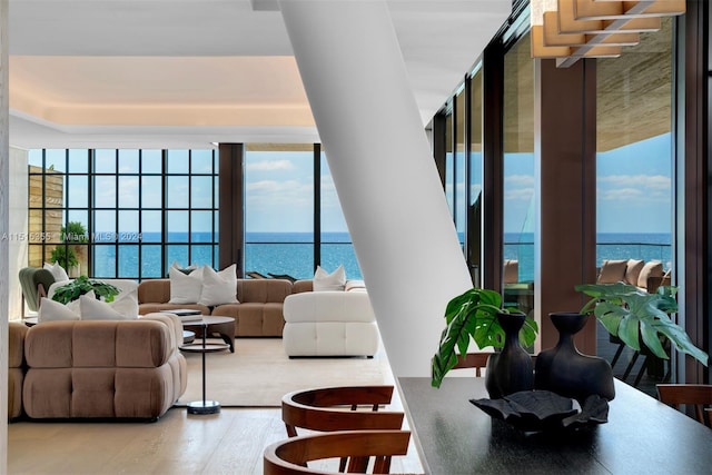 living room featuring expansive windows, a water view, and hardwood / wood-style flooring