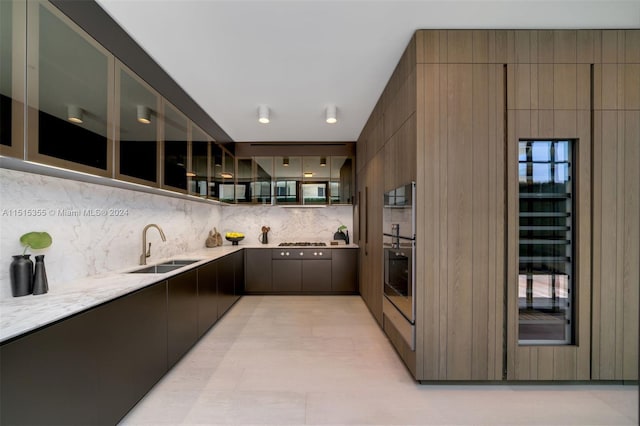 kitchen with sink, stainless steel oven, gas cooktop, tasteful backsplash, and light tile patterned flooring