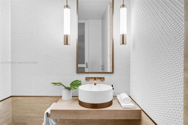 bathroom featuring vanity and tile walls