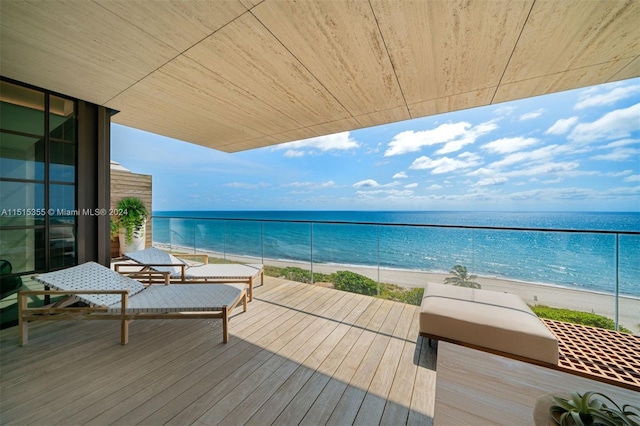 balcony with a water view and a view of the beach