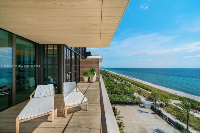 balcony with a water view and a view of the beach