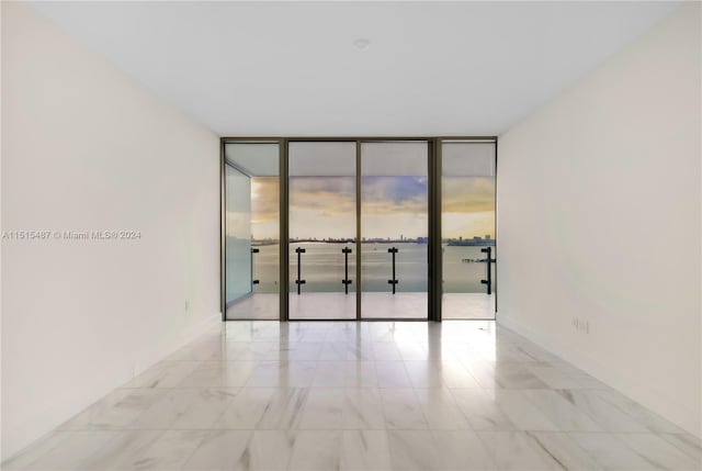 tiled spare room with floor to ceiling windows