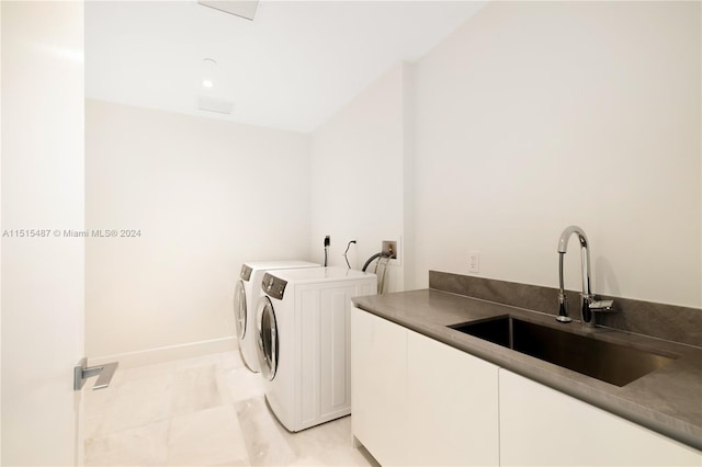 clothes washing area featuring washer hookup, light tile flooring, cabinets, washing machine and clothes dryer, and sink