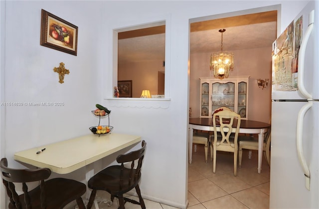 tiled dining space with a chandelier