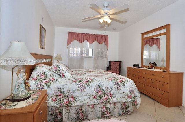 bedroom with ceiling fan, light tile patterned floors, and a textured ceiling