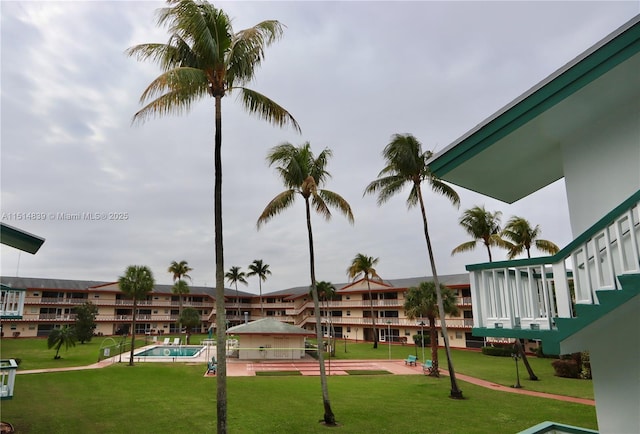 view of property's community featuring a lawn and a swimming pool