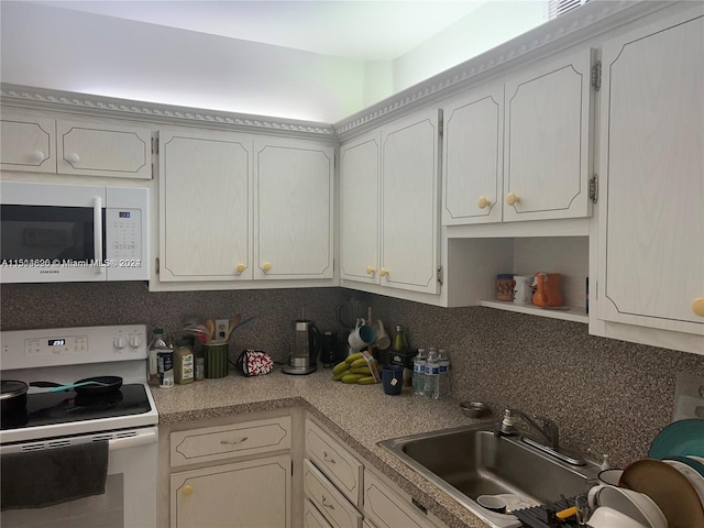 kitchen featuring white cabinets, backsplash, white appliances, and sink