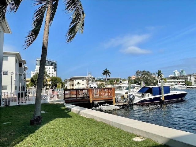 dock area with a water view and a lawn