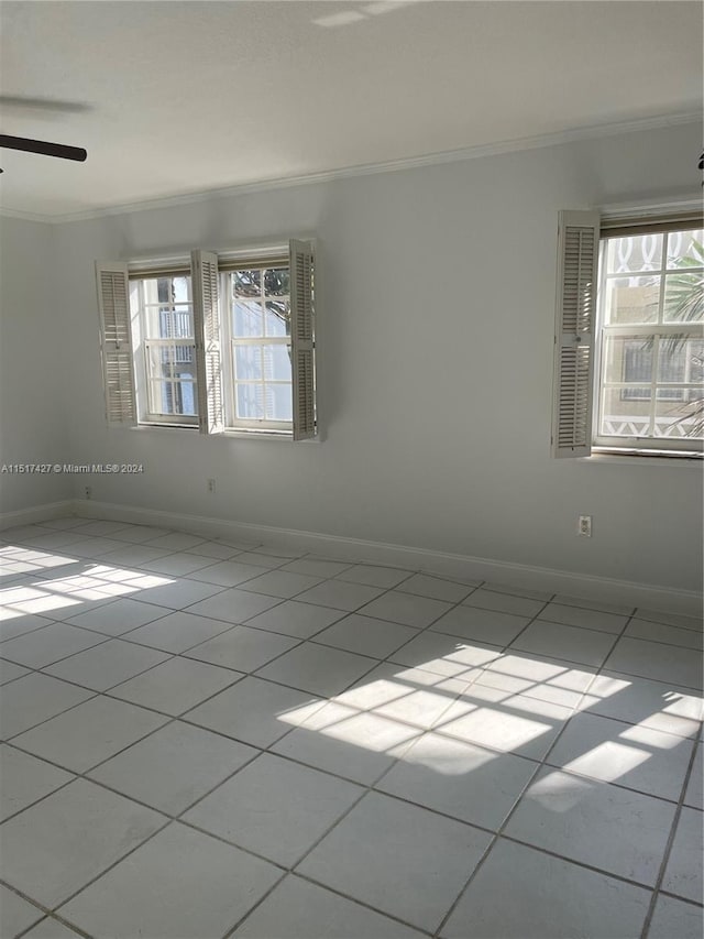 unfurnished room featuring tile flooring, ornamental molding, and ceiling fan