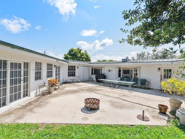 back of property featuring a patio area and an outdoor fire pit