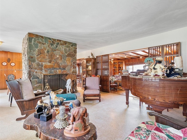 living room with a stone fireplace and wooden walls