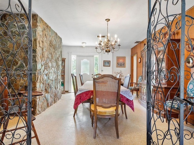 dining area with an inviting chandelier and a textured ceiling